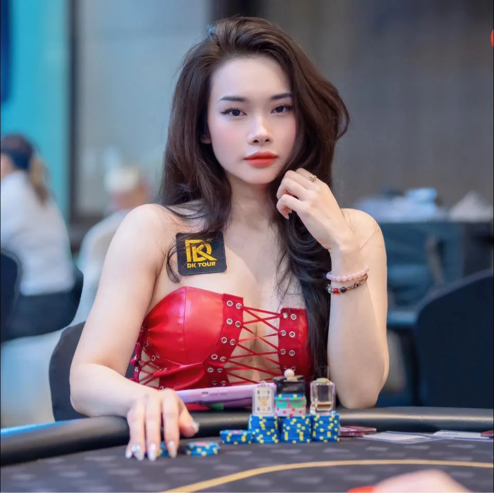 Gemmy Tuệ An at the poker table in red outfit